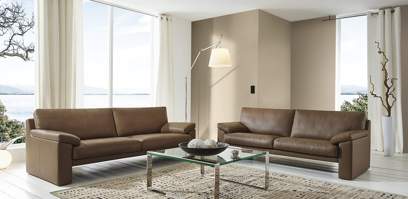 CL600 Sofas aus braunem Leder mit Glastisch in modernem Wohnzimmer am See