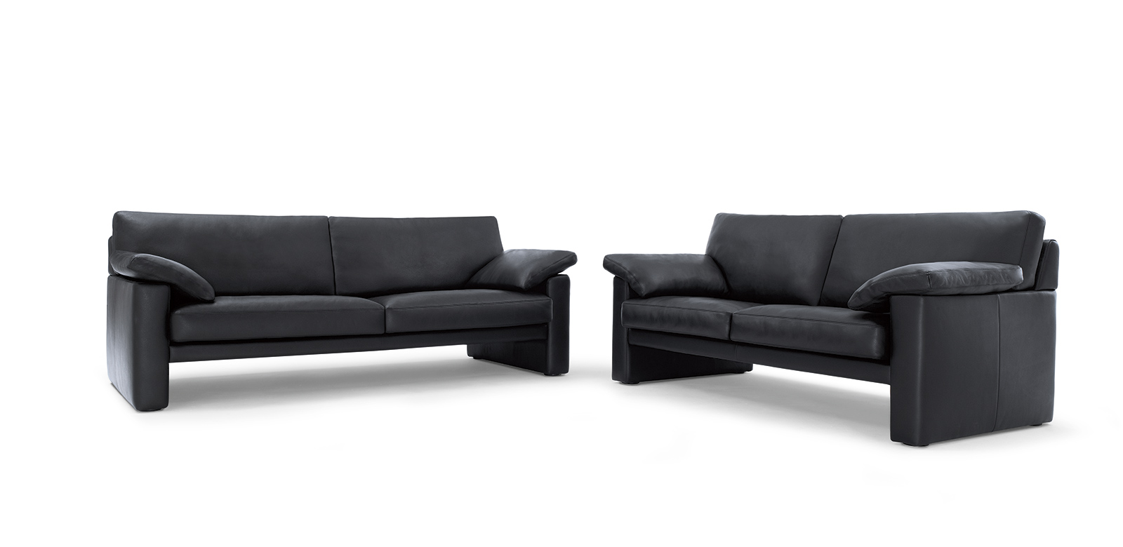 CL300 vrijstaande sofa's in zwart leer met armleuningkussens.