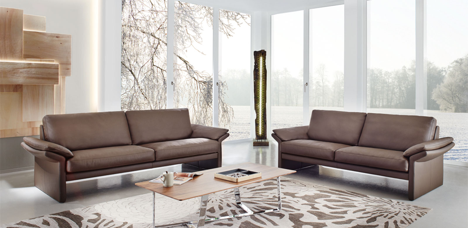 Zwei CL910 Sofas aus braunem Leder in modernem Wohnzimmer und Terrasse zum Wald