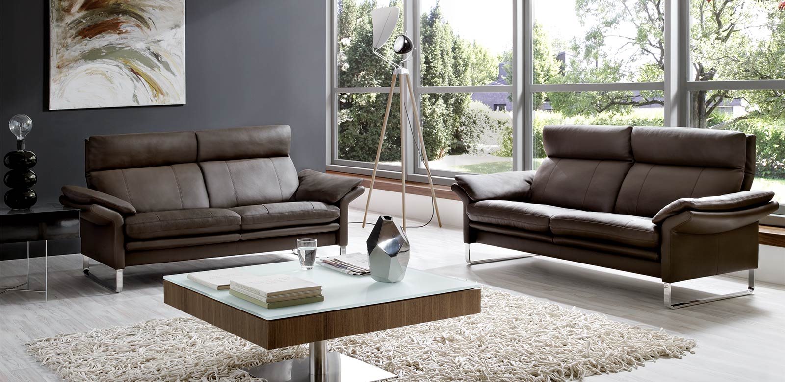 Lucca in grey-brown leather in the spacious living room with coffee table.