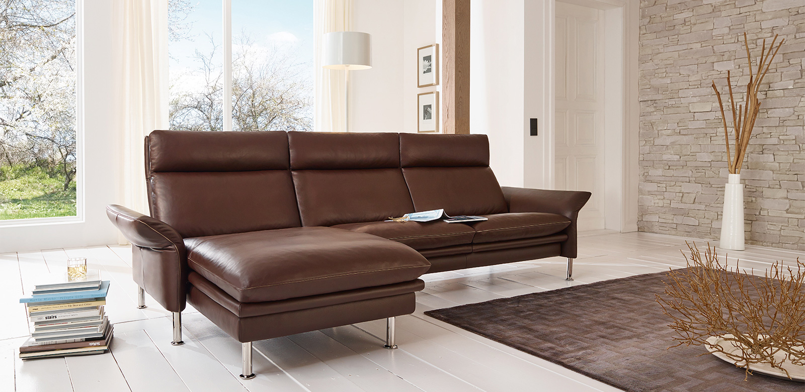 The accentuation of the cushion look on this fine leather sofa is a promise of the highest seating comfort. The softness of the upholstery goes hand in hand with very delicate lines, which are evident in all elements to perfection. In all details - from the slender feet to the armrests that fold in at the sides to the backrest - this leather sofa reveals Erpo's sense of lightness and elegance in couch sets to a special degree.