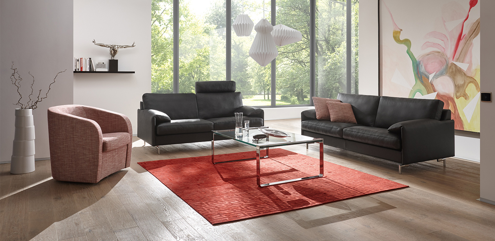 Two CL880 sofas with black leather, armchair in light red fabric and square glass coffee table on red carpet in modern living room with terrace